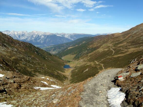 Der Blick talauswärts reicht über die gesamte Auffahrtsroute mit Nafingsee, Nafingalm und Weidener Hütte, sogar bis hinaus ins Inntal und zum Stanser Joch