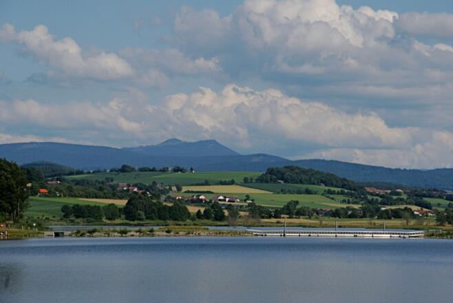 Drachensee mit schwimmender Brücke und Ossergipfeln im Hintergrund