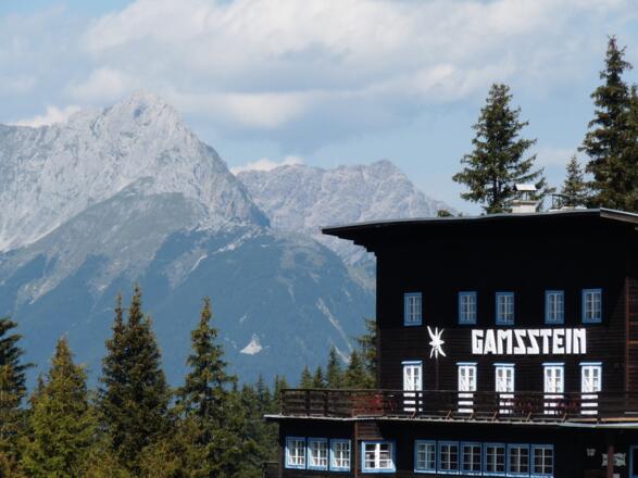 Das ehrwürdige Gamssteinhaus ist erreicht. Hinten grüßen die Karwendelberge herüber.