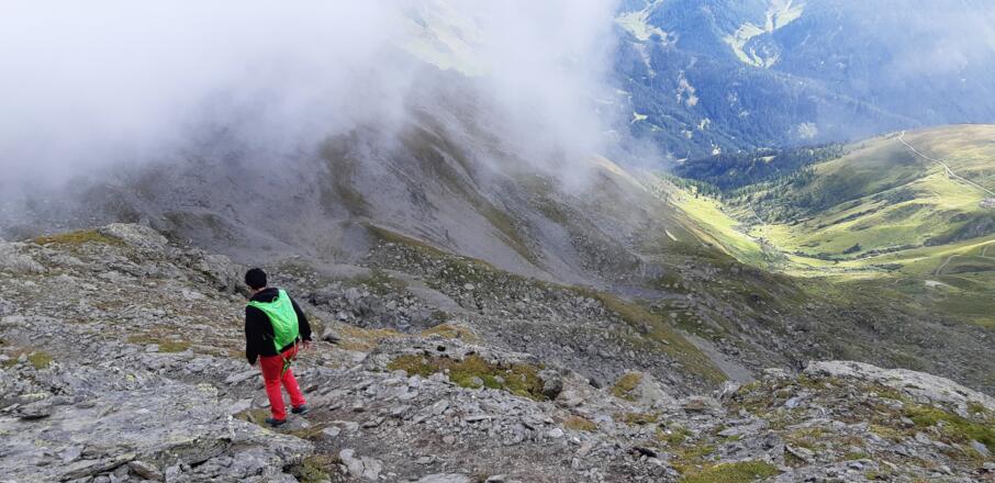 Abstieg von der Grünbergspitze. Blick hinunter ins Navistal, zur Grünberg- und Seapnalm.