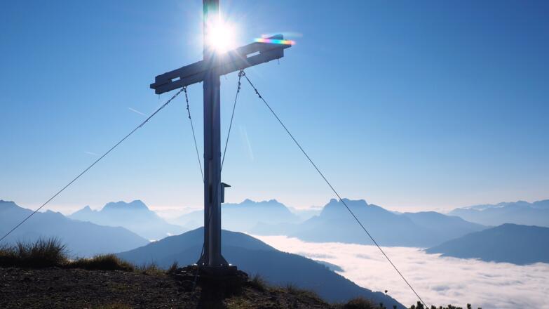 Kitzstein Kreuz 1925m mit Gesäusebergen im Hintergrund.