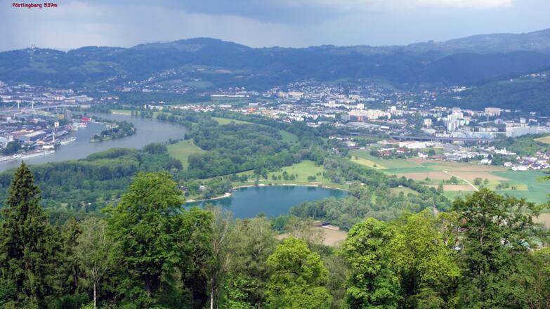 Blick NW über den Pleschingersee und Donauhafen zum Pöstlingberg
