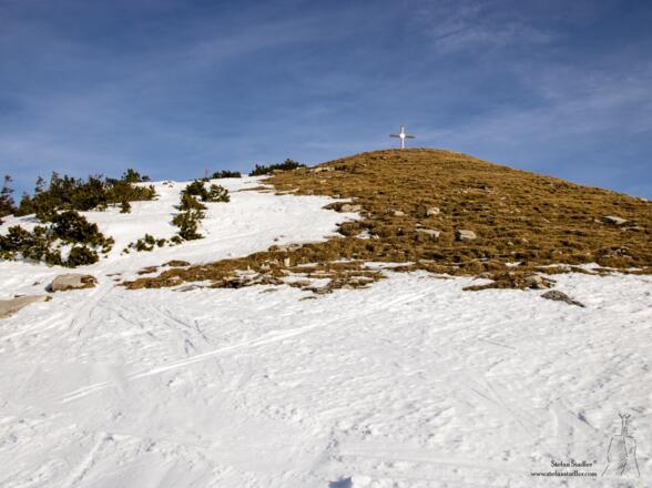 Plötzlich erscheint das Gipfekreuz des Hohen Zinken am Horizont.