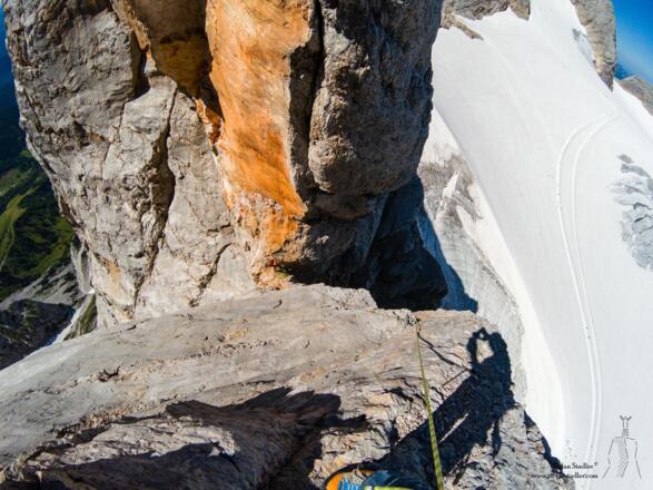 Blick zurück in die Scharte: Grüne Wiesen, grauer Fels, weißer Gletscher