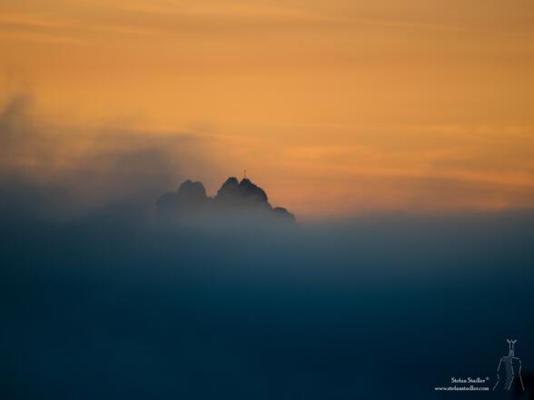 Unser Startpunkt - die Kampenwand - ragt aus dem Talnebel ins Abendrot.