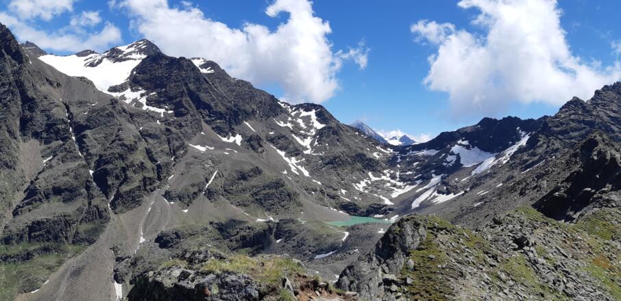 Der Grastalsee, eingebettet zwischen Breiten Grieskogel und Hörndle, wird sichtbar.
