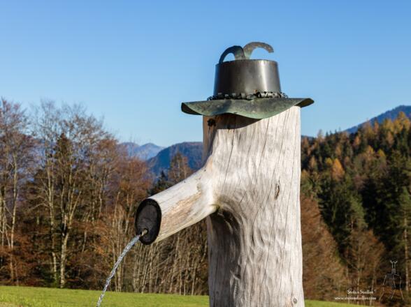 Brunnen mit Trachtenhut am Gasthof Dürrlehen.