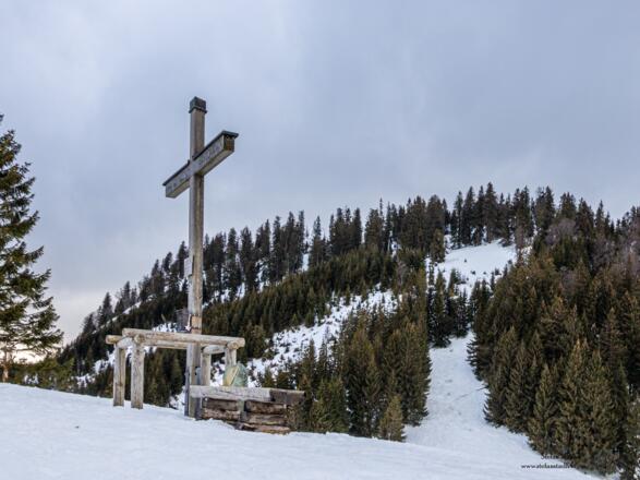 Das Kreuz bei der Bergwachthütte mit dem Eisenberg im Hintergrund.
