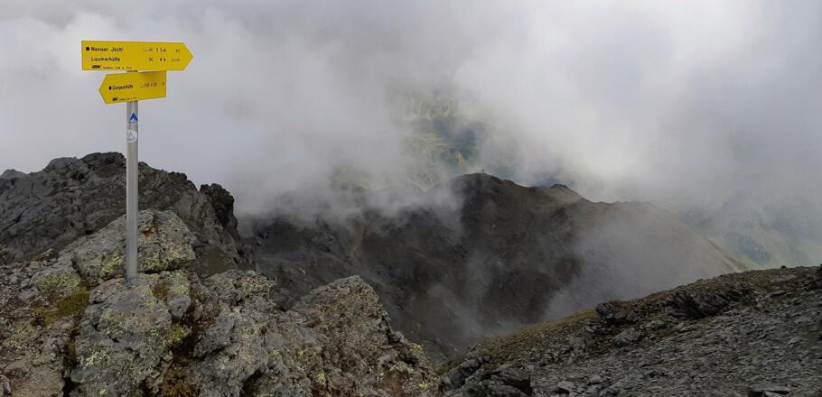 Wegweiser am Gipfel der Grünbergspitze. Unten kann man das Gipfelkreuz der Grafmartspitze erkennen.