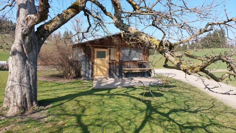 Gartenhaus, davor ist eine Sitzgelegenheit