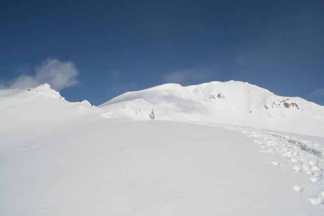 Der Anstieg entlang des Bergrückens führt hinauf zu einem markanten Felskopf (links).