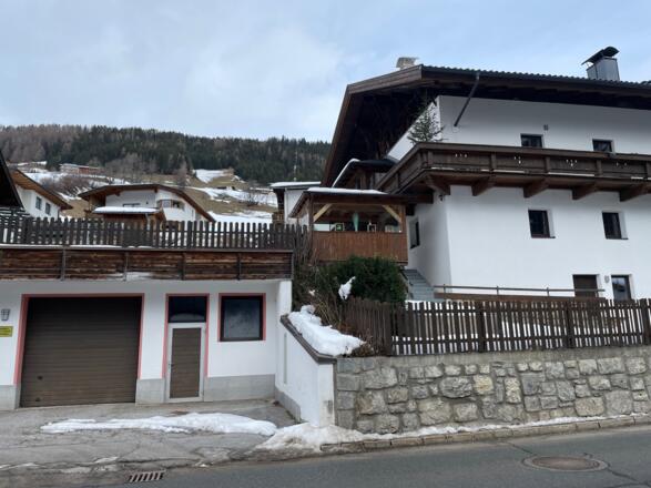 Blick von Kopfers zwischen den Häusern hinauf zu den Bergwiesen.