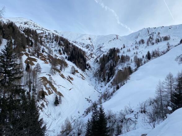 Keinesfalls sollte man durch diesen Graben aufsteigen. Im Hintergrund leicht rechts kann man bereits die steile Mulde erkennen.