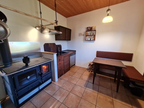 Küche mit Holzofen, normalem Herd, Spülmaschine, Kühlschrank...