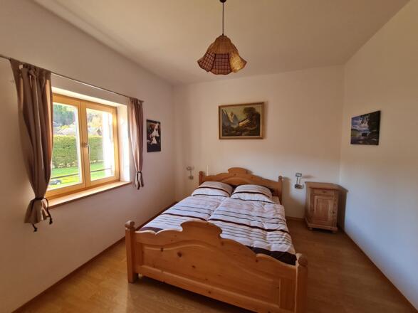 Großes Schlafzimmer mit Doppelbett, Kleiderschrank und Waschbecken Blick in den hinteren Garten