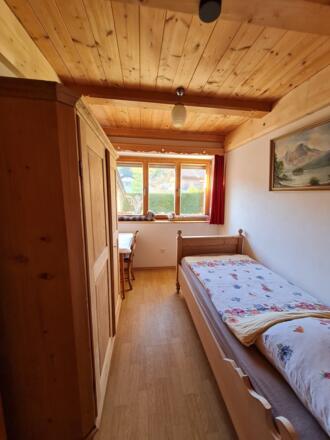 Einzelzimmer mit Einzelbett und Kleiderschrank Blick zum hinteren Garten