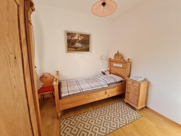 Einzelzimmer mit Einzelbett, Kleiderschrank und Waschbecken Fenster zum Freisitz / Wintergarten