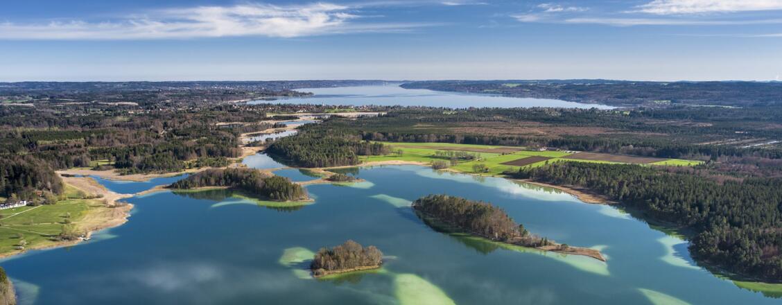 Luftaufnahme mit Blick auf die Osterseen und den Starnberger See am Horizont