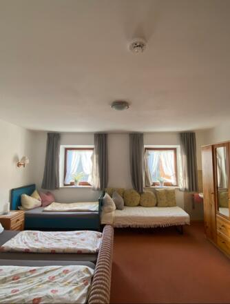 Schlafzimmer mit Doppelbett und zwei weiteren Einzelbetten