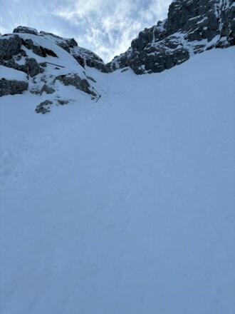 Einstieg. Oben links am Fels das Stahlseil.