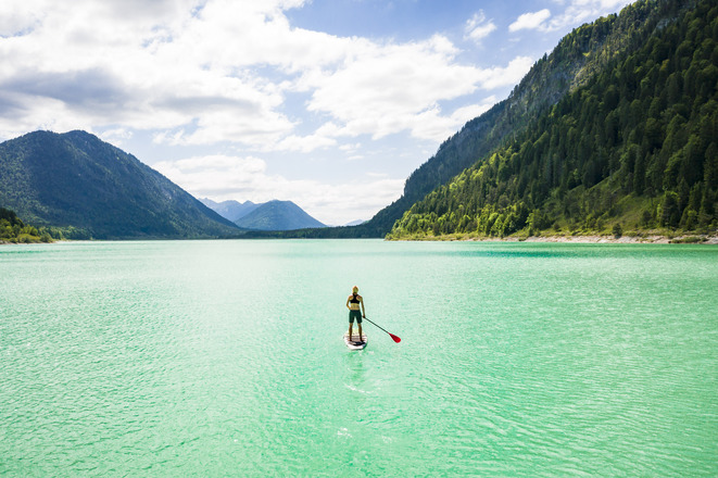 Fjordartiger Sylvensteinsee mit SUP-Paddler