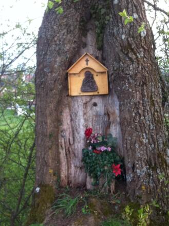 Mit Blumen geschmückter Bildstock