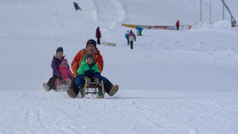 Rodler auf der Piste des Rodellifts