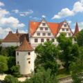 Panoramablick auf das Schloss Ratibor mit seinen Türmen und grünen Bäumen in Roth.