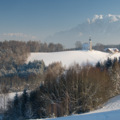 Kirche und Wirtshaus vor Bergkulissee: Johannishögl in Piding im Winter