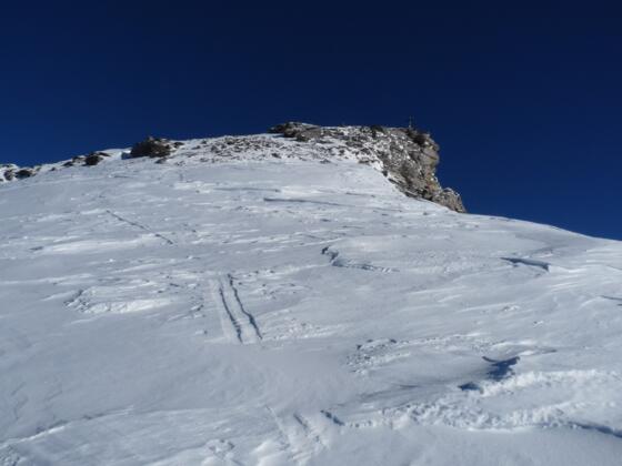 Erstmals in der Sonne auf dem breiten Gipfelrücken. Hinten ist bereits das Gipfelkreuz zu erkennen.