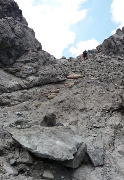 Von der tiefsten Stelle steigen wir steil über Holzstufen und mit Drahtseil auf.