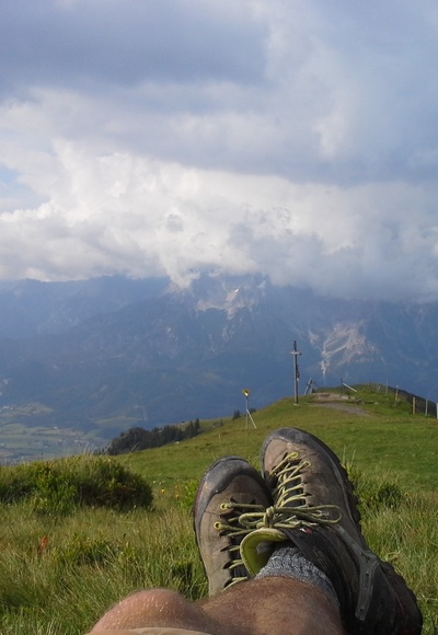 Gipfelrast mit Blick aufs Wolkenverhangene Steinerne Meer und Saalfelden. 