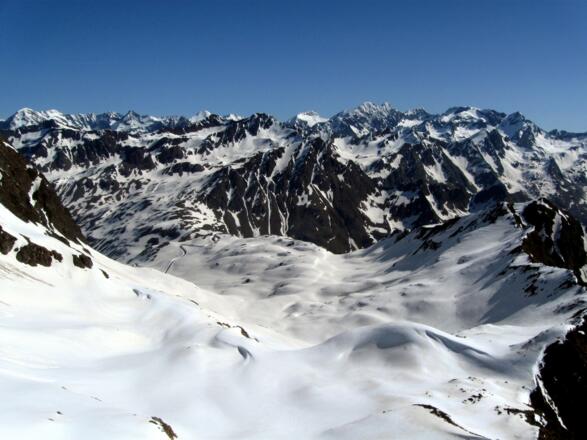 Der Blick reicht über das gesamte Tal bis hinaus zur Passhöhe.