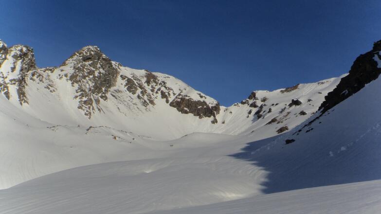 Blick Richtung Kleines Horntaler Joch (tiefster Punkt). Links der Blechnerkamp und rechts vom Joch die Horntalspitz. Hier im Schattenbereich aufsteigen und dann nach rechts auf eine breiten Rücken.