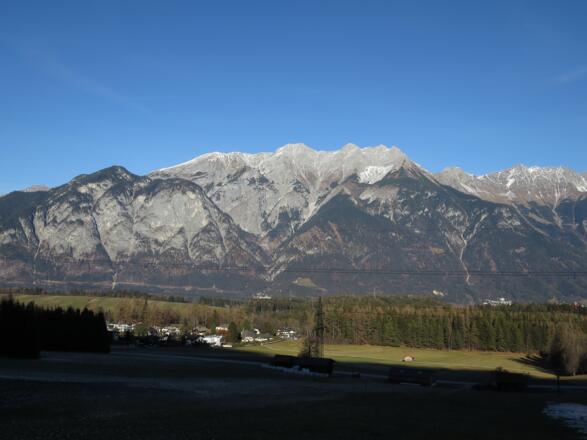 Die Kranebitter Klamm (Bildmitte), links vorne der Hechenberg, hinten Großer und Kleiner Solstein, Hohe Warte und Brandjoch, rechts hinten die Nordkette.