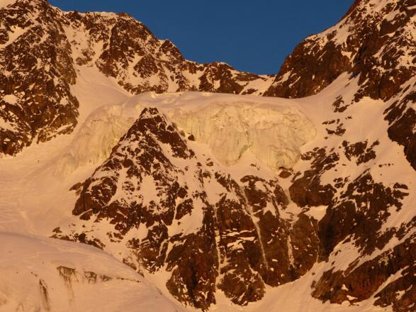 Der mächtige Hängegletscher, links zum Größenvergleich ein Skibergsteiger im Aufstieg.