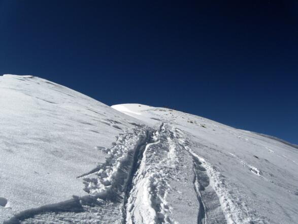 Die letzten Meter auf die Scheibenspitze führen auf der Nordseite des Grates zum Gipfelkreuz