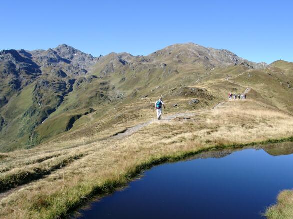 Vom Sidanjoch aus verläuft der Weg auf einem breiten Rücken zunächst auf den Rosskopf zu. Links davon zeigt sich der Rastkogel.