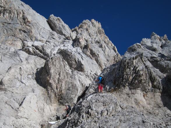 Willkommene Abkühlung durch letzte Reste Herbstschnee. Die Rinne nach rechts oben vermittelt den Weiterweg.