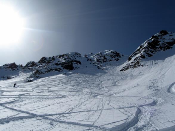 In einem weiten Rechtsbogen geht es aufwärts. In der Bildmitte ist bereits das Gipfelkreuz zu sehen. Durch eine der beiden Steilrinnen (Mitte) muß man aufwärts, entweder mit Schi oder zu Fuß mit den Schiern am Rucksack.