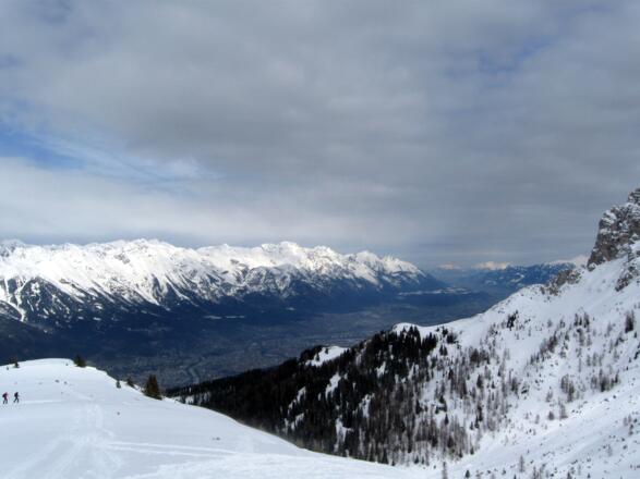 Blick nach Osten - Unten liegt Innsbruck, oberhalb die Nordkette, im Vordergrund das Pfriemesköpfl mit der Bergstation der Muttereralm Bahn.