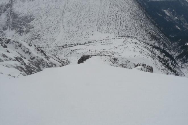 Blick von der Gipfelflanke hinunter zur Einsattelung, wo sich das Solsteinhaus befindet.