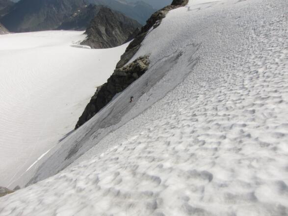 Die gesamte Nordflanke von oben, hinten der Berglasübergang. Der Seilerste hat seinen letzten Standplatz bereits am flachen Gipfelgrat errichtet.