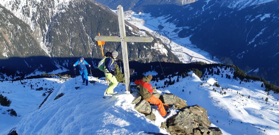 Gipfelkreuz der Seblasspitze (Wintergipfel), unten Neustift im Stubaital.