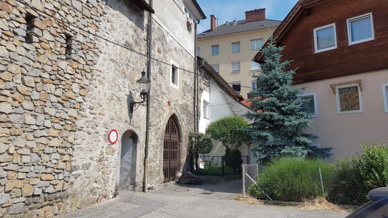 Vorbei am Stadttor in der historischen Stadtmauer von Steyregg