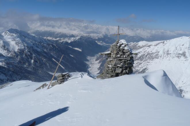 Große Steinmänner und eine Statue (nicht sichtbar) zieren den Gipfel. Tiefblick auf das Valsertal.