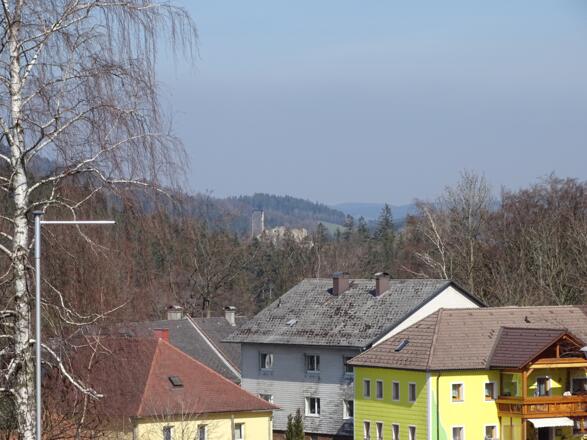 Straße durch St. Thomas, im Hintergrund die Burgruine Klingenberg