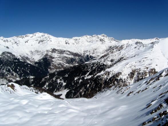 Am Grat schaut man hinunter in die gewaltigen Böden oberhalb der Blasigleralm. Auf der gegenüberliegenden Talseite: Grünbergspitze, Naviser Sonnenspitze, Mölsjoch und Mölser Sonnenspitze.