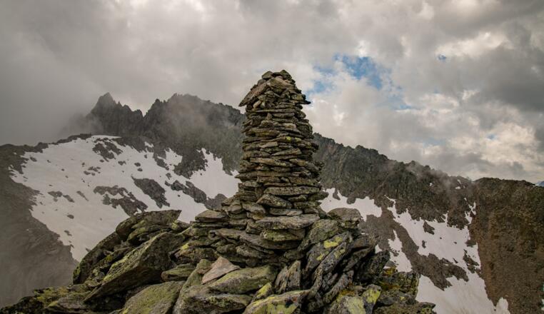 Ein Steinmanderl auf dem Gipfel - im Hintergrund die Mittlere Grinbergspittze