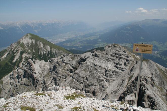 Am Gipfel der Marchreisenspitze. Blick zurück auf Ampferstein und Nockspitze. Die Tafel mit dem "Lustigen-Bergler-Steig" weist darauf hin, dass der Steig nur von Geübten begangen werden soll.